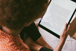 Person reading textbook on tablet (Photo: RF._.studio/Pexels)